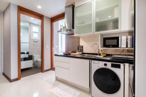 a kitchen with a washer and a sink and a washing machine at White Sands Beachfront l 2BR Condo with Ocean View in Na Jomtien