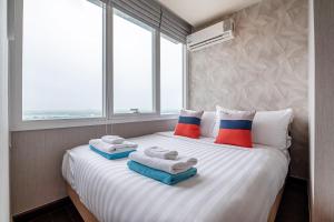 a bedroom with a large bed with towels on it at White Sands Beachfront l 2BR Condo with Ocean View in Na Jomtien