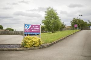 a sign for a hotel car park next to a road at The Welcome Inn in Rotherham