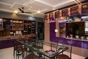 a dining room with a glass table and purple walls at Osho Sumeru K Homestay-Kitchen-Free Parking-Fast Wifi-AC in Mātigara