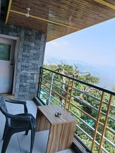 a room with a table and a chair on a balcony at The Hostelers Homestay Shimla - Near ISBT, Bypass MC Parking and HPU in Shimla +36 photos