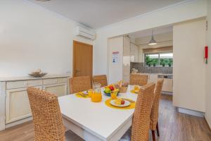 a kitchen and dining room with a white table and chairs at #010 Marina View Apartment Pool & Balcony in Albufeira