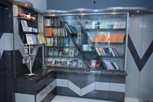 a book shelf filled with books in a library at Osho Sumeru K Homestay-Kitchen-Free Parking-Fast Wifi-AC in Mātigara