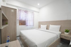 a bedroom with a large white bed and a window at Hotel Shubh Bodhi in Bodh Gaya