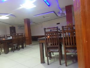 a dining room with wooden chairs and a table at The aditya hotel & Resturdent in Bhukhar