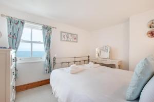 a bedroom with a bed and a window with the ocean at 2 Bed in Sandsend oc-wa317 in Sandsend