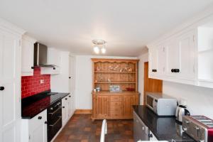 a kitchen with white cabinets and black counter tops at 2 Bed in Sandsend oc-wa317 in Sandsend
