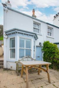 a wooden picnic table in front of a white house at 2 Bed in Sandsend oc-wa317 in Sandsend