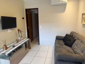 a living room with a couch and a tv at Flat com linda vista no Monte Castelo in Sairé
