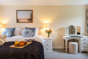 a bedroom with a bed with a tray of food on it at Wynmere Cottage in Chipping Norton