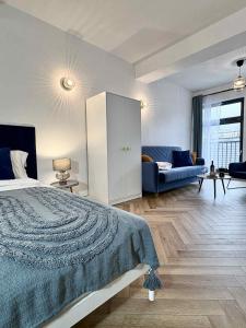 a bedroom with a large bed and a couch at Apartamenty Staszica in Bielsko-Biała