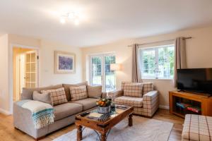 a living room with a couch and a tv at Wynmere Cottage in Chipping Norton