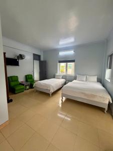 a bedroom with two beds and a room with a couch at KHÁCH SẠN NGỌC LY 5 in Thanh Hóa