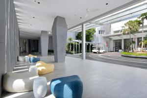 a lobby with yellow and blue chairs and a building at White Sands Beachfront l 2BR Condo with Ocean View in Na Jomtien