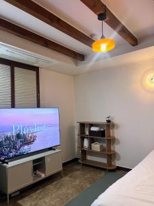 a bedroom with a large flat screen tv on a wall at Stay Us 3151 in Seongnam +31 photos
