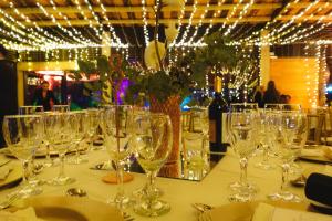 a table with wine glasses on a table with lights at Sauron Adventure in Cuesta Blanca
