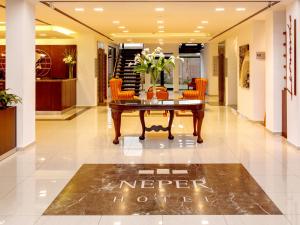 a lobby with a coffee table and orange chairs at Neper Hotel in Córdoba