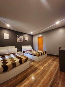 two beds in a room with wooden floors at West Peninsula Villas in Harrison