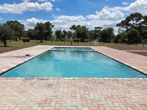 a swimming pool with blue water in a park at Bush Diamond Lodge in Cullinan
