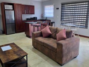 a living room with a couch and a kitchen at Bush Diamond Lodge in Cullinan