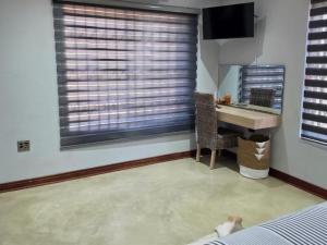 a bedroom with a desk and a sink and a window at Bush Diamond Lodge in Cullinan