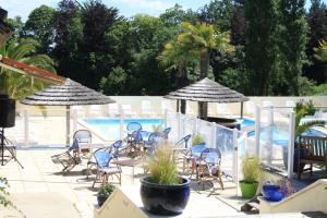 a patio with chairs and a swimming pool with umbrellas at Camping Kerscolper - Mobil home 3 pièces 4/6 personnes + TV MAE-9591 in Fouesnant +56 photos