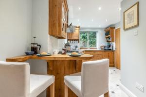 eine Küche mit Holzschränken und einer Theke mit Stühlen in der Unterkunft 3 Bed in Baslow oc-h27288 in Baslow