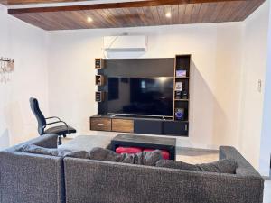a living room with a couch and a flat screen tv at Casas Villa azul in Tanti