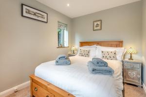 ein Schlafzimmer mit einem großen weißen Bett, auf dem Handtücher liegen in der Unterkunft 3 Bed in Baslow oc-h27288 in Baslow