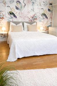 a bedroom with a white bed with a floral wallpaper at Suites in Mödling in Mödling