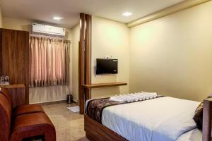 a hotel room with a bed and a television at Hotel M S Chola in Chennai +23 photos