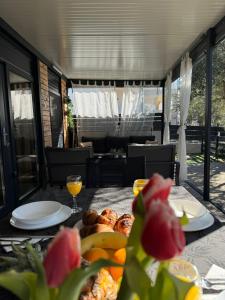 a table with food on top of it with a glass of orange juice at Mobile Home Clelia in Sveti Petar