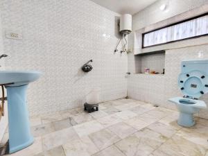 a bathroom with a blue toilet and a sink at Perth villa in Mount Ābu