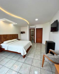 ein Schlafzimmer mit Bett und Flachbildfernseher in der Unterkunft Hotel Torre Azul in Santo Domingo de los Colorados