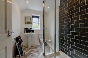 a bathroom with a shower and a toilet and a sink at 4 Bed in Tenby oc-t27576 in Tenby +20 photos