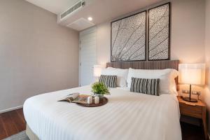 a bedroom with a large white bed with two windows at White Sands Beach-Beach Access-1BR-Amazing View2 in Na Jomtien