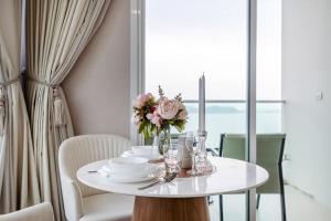 a white table with a vase of flowers on it at White Sands Beach-Beach Access-1BR-Amazing View2 in Na Jomtien