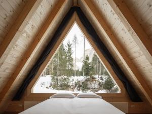 a bed in a room with a large window at Camping Cadore in Selva di Cadore