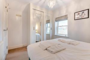 a white bedroom with a bed and a window at 2 Bed in Swanage oc-wy527 in Swanage