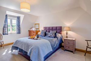 a bedroom with a bed with a blue bedspread at 2 Bed in Lindsey oc-w28111 in Monks Eleigh