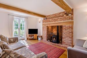 a living room with a brick fireplace and a tv at 2 Bed in Lindsey oc-w28111 in Monks Eleigh