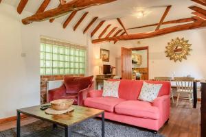a living room with a pink couch and a table at 1 Bed in Saxmundham oc-c27420 in Farnham
