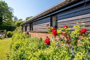 a house with red flowers in front of it at 1 Bed in Saxmundham oc-c27420 in Farnham +4 photos