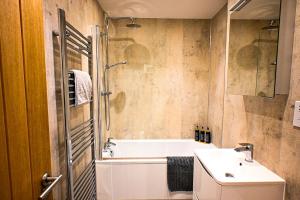 a bathroom with a tub and a sink and a toilet at Enbrook View in Sandgate +27 photos