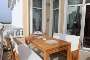 a wooden table and chairs on a balcony with windows at Barbie-Themed 3BDR Penthouse Near The Beach, Nessebar in Nesebar +74 photos