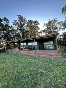 a house with a large deck in the grass at Bodegas y Viñedos Balcarce in Balcarce