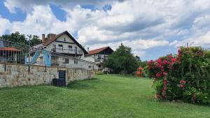 a large white house with a brick wall and flowers at Villa “Nadezhda” in Tsareva Livada
