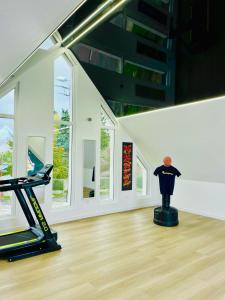a room with a gym with a treadmill and windows at Appartement cosy ambiance Palm Spring dans résidence avec piscine 4 pers 2 chambres in Neuf-Mesnil