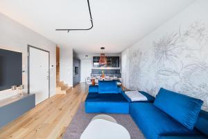 a living room with a blue couch and a table at Luxury Villa Prestige in Sirmione