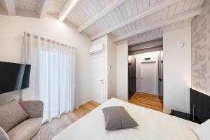 a bedroom with a white bed and a couch at Luxury Villa Prestige in Sirmione +38 photos
